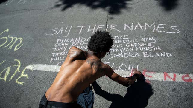 A man writes a message in chalk on H St. NW, near the section of 16th Street dubbed Black Lives Matter Plaza after days of demonstrations to honor George Floyd and victims of racial injustice on Monday, June 8, 2020.