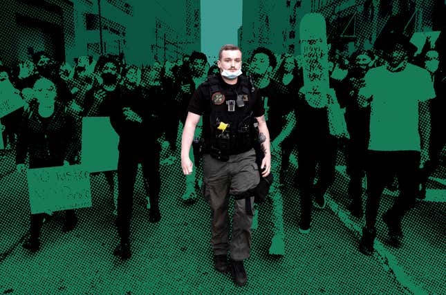 A Detroit police officer walks through demonstrators during protests on May 29, 2020. The badge on his chest, depicting Frank Castle’s Punisher skull on a green field alongside the words “Detroit Police,” is one of several designs using the imagery spotted on Detroit PD officers during recent protests.