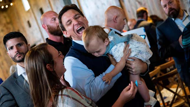 DeSantis holds a baby during a campaign event at Sun Valley Barn in Pella, Iowa, US, on May 31, 2023.