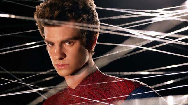 Peter Parker, wearing his Spider-Man suit but maskless, stands amid spider webs.