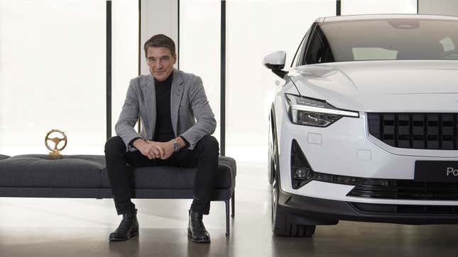 A photo of Polestar CEOThomas Ingenlath sat next to one of his company's electric cars. 