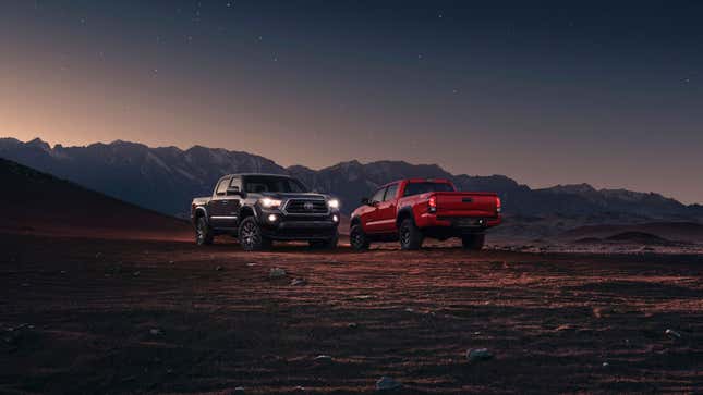 A photo of two Toyota Tacoma pickup trucks at sunset. 