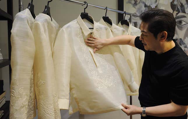 This photo taken on November 12, 2015 shows Filipino designer Paul Cabral explaining how he designed the "barong" or formal shirts that Asia-Pacific Economic Cooperation (APEC) leaders will wear during the summit this week in Manila. The twenty-two leaders of the Asia Pacific Economic Cooperation (APEC) will wear the "barong tagalog", the Philippines' formal shirt, with each garment custom-embroidered with their country's symbols. Cabral is hoping to buck the trend with his creations, which took four months to design and sew painstakingly by hand.