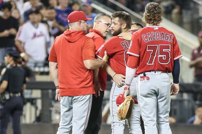Aug 26, 2023; New York City, New York, USA;  Los Angeles Angels starting pitcher Chase Silseth (63) is checked on after getting hit in the head by a throw in the fourth inning against the New York Mets at Citi Field.