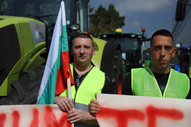Farmers hold a Bulgarian flag during a protest in the town of Pernik, Monday, Sept. 18, 2023. Farmers in Bulgaria blocked major roads and border crossings nationwide on Monday to protest against their government&#39;s decision to lift a ban on imports of food products from Ukraine, complaining that products from the war-torn country will cause an influx and distort local prices. (AP Photo/Valentina Petrova)