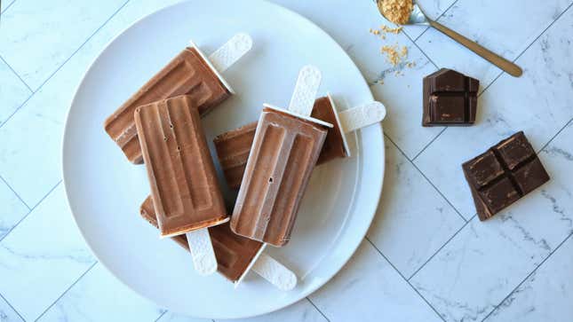 Chocolate popsicles stacked on a plate.