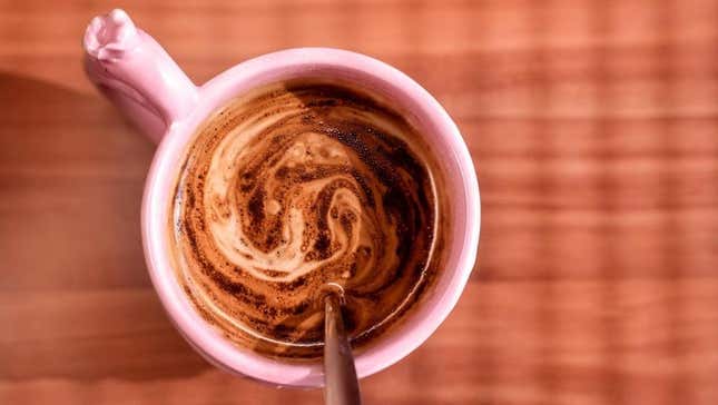 Instant coffee being stirred into mug