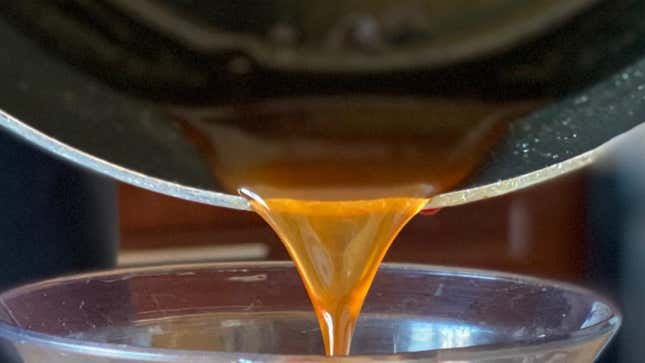 Close-up shot of apple cider syrup pouring into a cup.