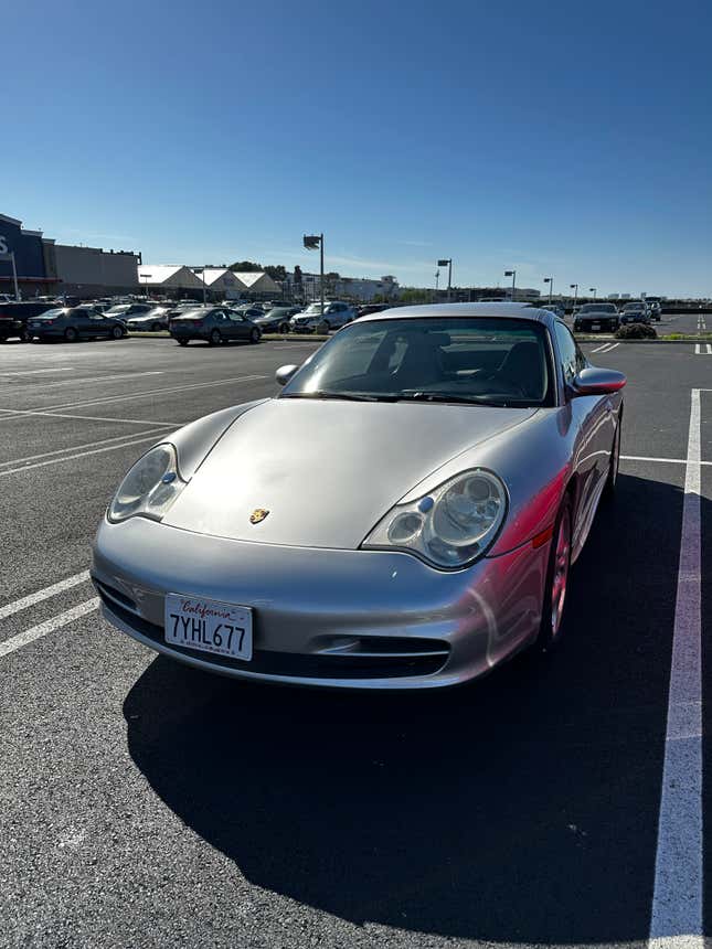 A silver 2003 Porsche 911 parked in a parking space.