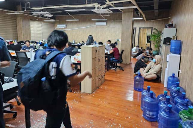 FILE - In this photo provided by the Philippine National Police Anti-Cybercrime Group, police walks inside one of the offices they raided in Las Pinas, Philippines, on June 27, 2023. The U.N. human rights office says criminal gangs have forced hundreds of thousands of people in Southeast Asia into participating in unlawful online scam operations, including false romantic ploys, bogus investment pitches, and illegal gambling schemes. (Philippine National Police Anti-Cybercrime Group via AP, File)
