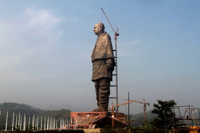 The under-construction statue of unity stands facing the Sardar Sarovar Dam.