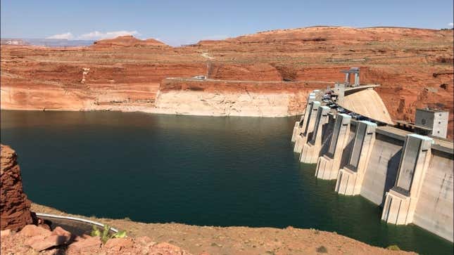 Glen Canyon Dam holds water in Lake Powell against a backdrop of red, desert rock.