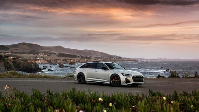 A matte silver 2024 Audi RS 6 Avant Performance is parked in front of the California coast during sunset