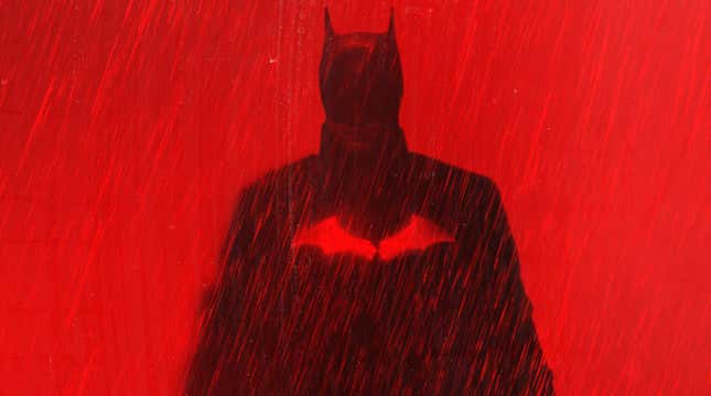 Robert Pattinson's Batman against a red background in a scene from The Batman.