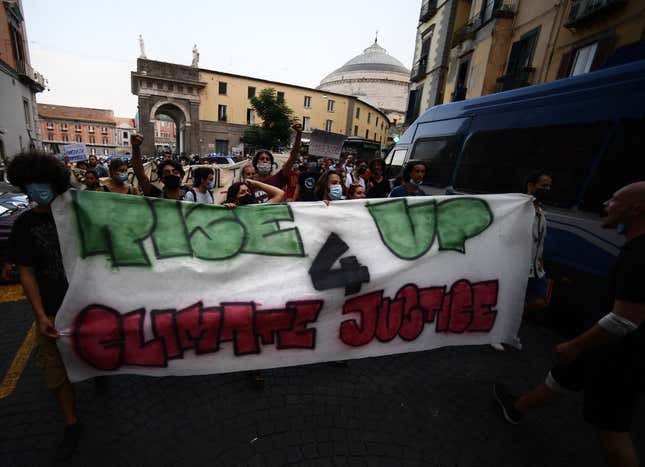 Protesters hold a banner in Naples on July 21, 2021, during a rally against the climate and energy G20 summit starting on July 22, 2021.