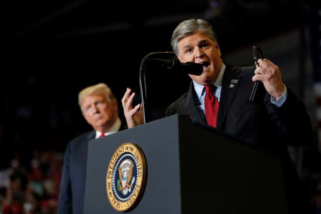 U.S. President Donald Trump listens as Sean Hannity from Fox News speaks at a campaign rally in Missouri