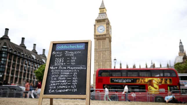A chalkboard that says Oddschecker and has written in chalk the exit odds of Boris Johnson and also odds for Next Prime Minister, with a number of names listed. In the background is seen Big Ben and a double decker bus.