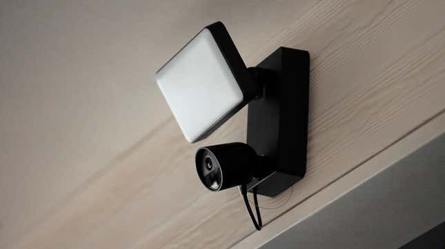 Philips Hue new Secure camera with attached flood light on a wall above a door.