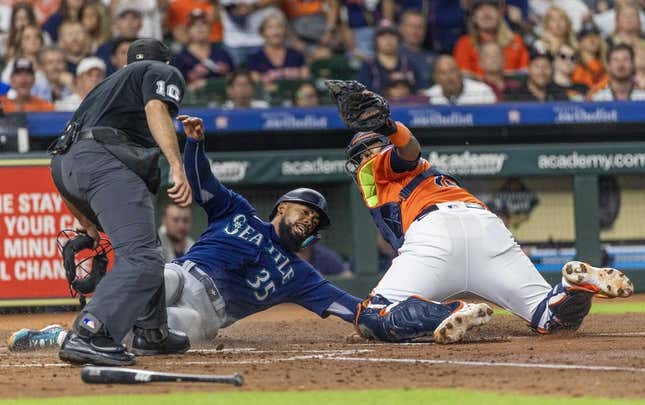Aug 18, 2023; Houston, Texas, USA; Home plate umpire Alex MacKay calls Seattle Mariners right fielder Teoscar Hernandez (35) out at home as he is tagged by Houston Astros catcher Martin Maldonado (15)  in the fourth inning at Minute Maid Park.