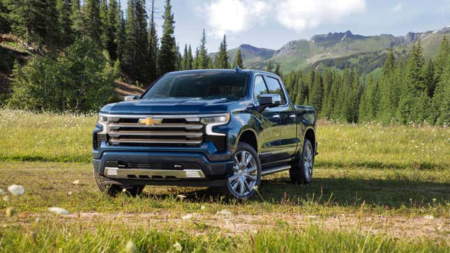 A photo of a blue Chevrolet Silverado truck parked in a field. 