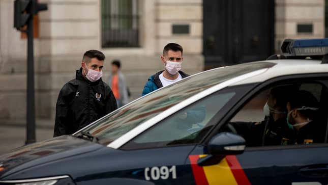 Spanish police in Madrid stop two pedestrians to tell them about the new coronavirus measures on March 15. Spain’s prime minister issued a national lockdown on March 14.