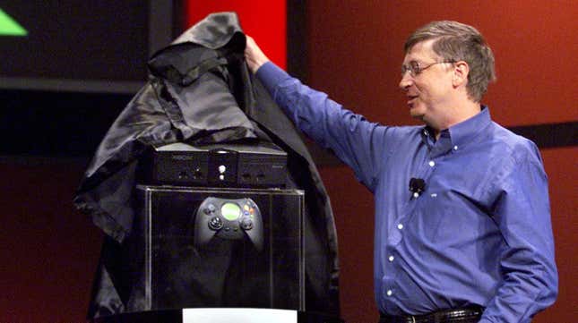 Microsoft's Bill Gates reveals the Xbox on stage, pulling off a black cover.