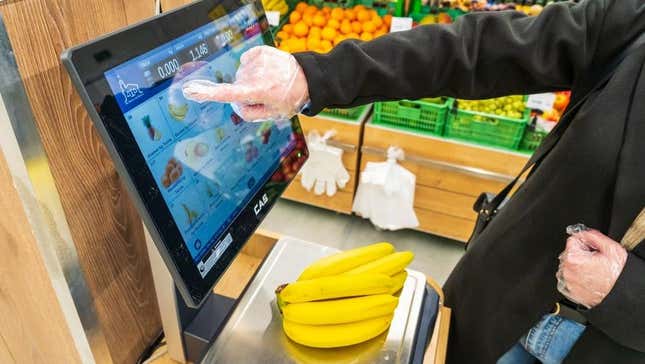 Shopper weighs bananas on self checkout kiosk