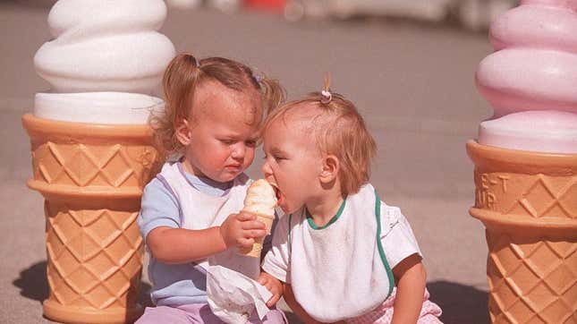 Toddlers sharing ice cream cone