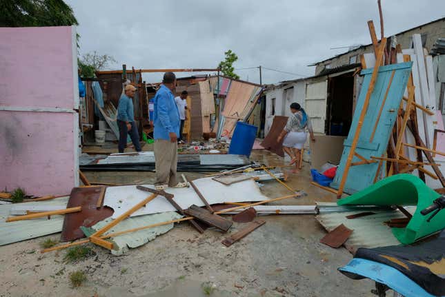 Photo of people standing amid damaged homes