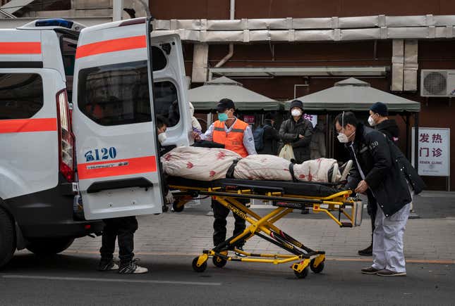 Ambulance drivers unload a patient outside a fever clinic treating covid patients in Beijing, China.