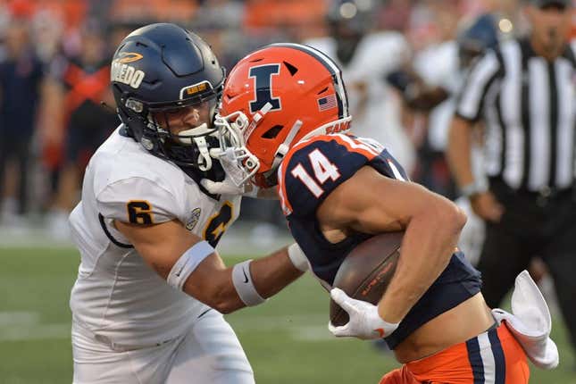 Sep 2, 2023; Champaign, Illinois, USA;  Toledo Rockets safety Nate Bauer (6) tries to tackle Illinois Fighting Illini wide receiver Casey Washington (14) during the first half at Memorial Stadium.