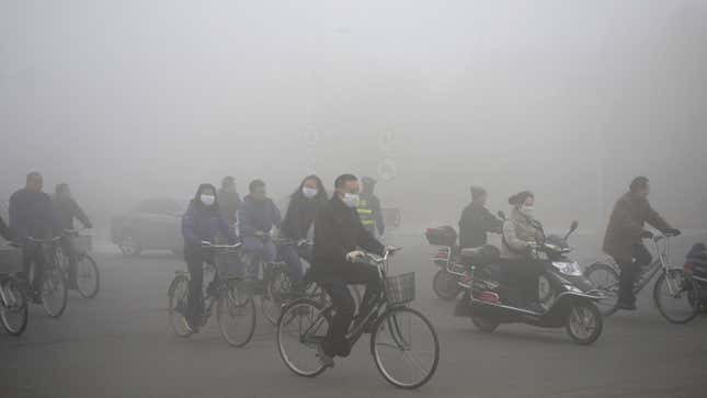 People ride along a street on a smoggy day in Daqing, Heilongjiang province, October 21, 2013. The highest red alert was issued for heavy smog in several cities in Heilongjiang province on Monday, according to Xinhua News Agency. The second day of heavy smog with a PM 2.5 index has forced the closure of schools and highways, exceeding 500 micrograms per cubic meter on Monday morning in downtown Harbin, the provincial capital. REUTERS/Stringer