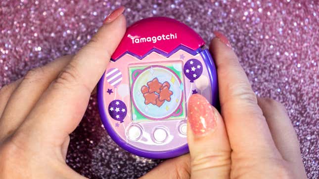 A photo of a person holding the Tamagotchi Pix Party