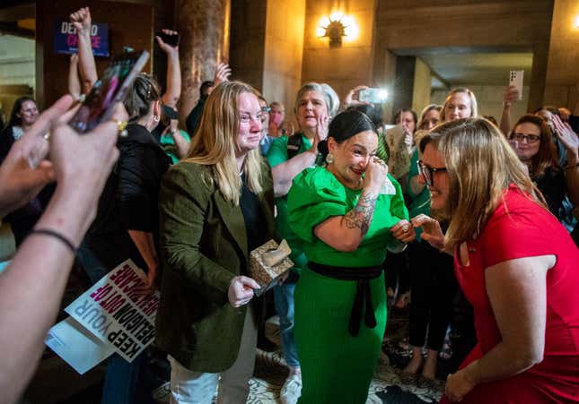 State Sens. Megan Hunt, from center left, Jen Day and Sen. Machaela Cavanaugh embrace in the Rotunda while being cheered on by supporters after a bill seeking to ban abortions in Nebraska after about six-weeks fails to advance, Thursday, April 27, 2023, at the Nebraska State Capital in Lincoln, Neb. 