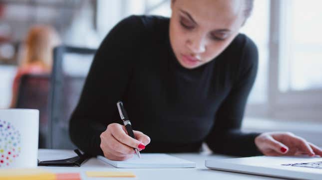 Young woman writing in notebook