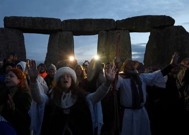 Visitors and revellers react amongst the prehistoric stones of the Stonehenge monument at dawn on Winter Solstice, the shortest day of the year, near Amesbury in south west Britain, December 21, 2016. REUTERS/Toby Melville - RC126FD0B770