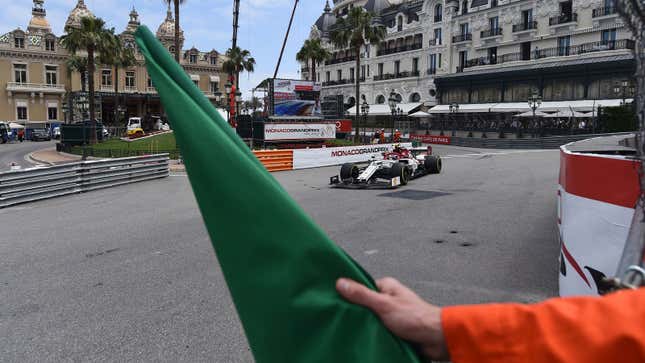 A photo of a marshal waving a green flag at the Monaco Grand Prix. 