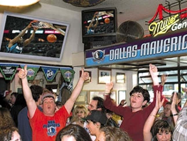 Dallas Mavericks fans cheer on their team while Senate Majority Leader Bill Frist (left) announced the passage of the terrifying new law.