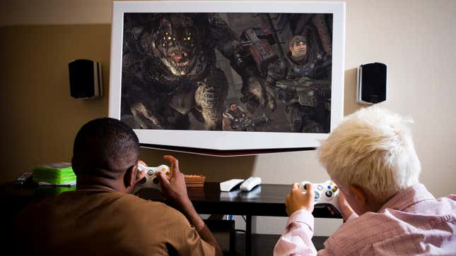 Two people play Xbox 360 together, with a Gears of War screenshot superimposed on the TV.