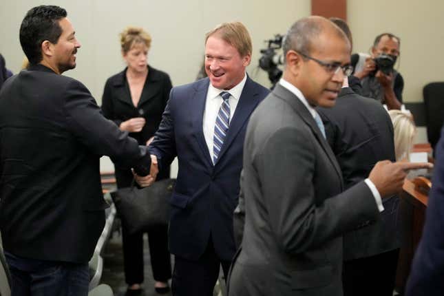 Jon Gruden, center, appears in court Wednesday, May 25, 2022, in Las Vegas. A Nevada judge heard a bid Wednesday by the National Football League to dismiss former Las Vegas Raiders coach Jon Gruden’s lawsuit accusing the league of a “malicious and orchestrated campaign” including the leaking of offensive emails ahead of his resignation last October.
