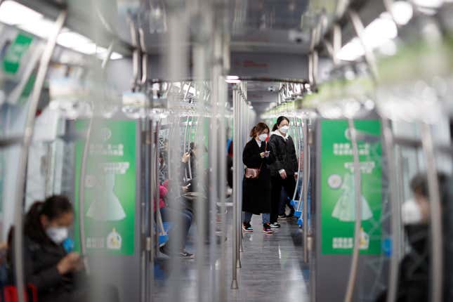 People wear face mask as they enter a subway train in Beijing as the country is hit by an outbreak of the novel coronavirus, China, March 10, 2020. REUTERS/Thomas Peter – RC2SGF9RAQK7