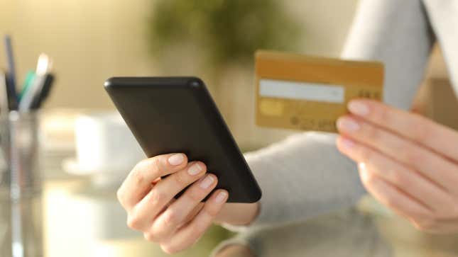 person holding phone and credit card