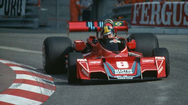 A photo of Carlos Pace racing a red F1 car at Brands Hatch. 
