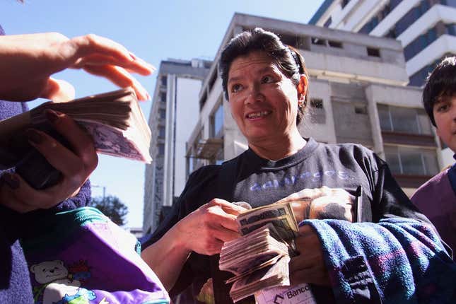 An Ecuadorian woman changes fistfulls of Sucres, the local currency, for US Dollars from a street currency trader in Quito's January 14. Ecuador's President Mahuad dollarized his country's economy in an effort to counter galloping inflation last weekend. The emergency measure has received a mixed welcome in Ecuador, with some supporting and others opposing the drastic step. Ecuadorian security forces are bracing themselves for several days of protests in the wake of the new policy. AW - RTRBBS