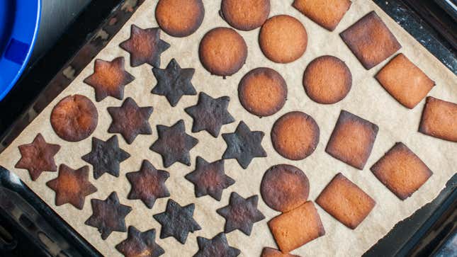 burnt holiday cookies on a parchment-lined baking sheet
