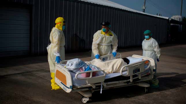 Healthcare workers push a patient into a less intensive unit from the Covid-19 Unit at United Memorial Medical Center in Houston, Texas.