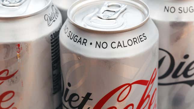 close-up of several cans of diet coke with "no sugar, no calories" printed on the top