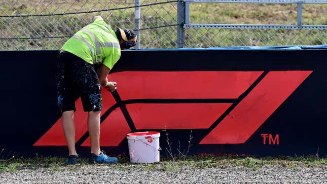 A worker paints the F1 logo on a board on the side of the tracks of Intercity Istanbul Park in Istanbul on October 7, 2021.