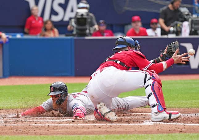 Jul 1, 2023; Toronto, Ontario, CAN; Boston Red Sox first baseman Justin Turner (2) slides into home plate scoring a run ahead of the tag from Toronto Blue Jays catcher Danny Jansen (9) during the fifth inning at Rogers Centre.