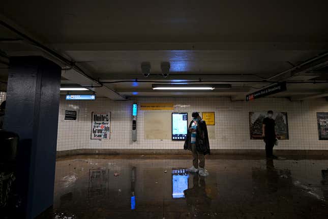A man wearing plastic bags over his shoes waits for the subway service  to resume as remnants of Hurricane Ida causes flash flooding across the  city, in the New York City borough of Queens, NY, September 1, 2021.